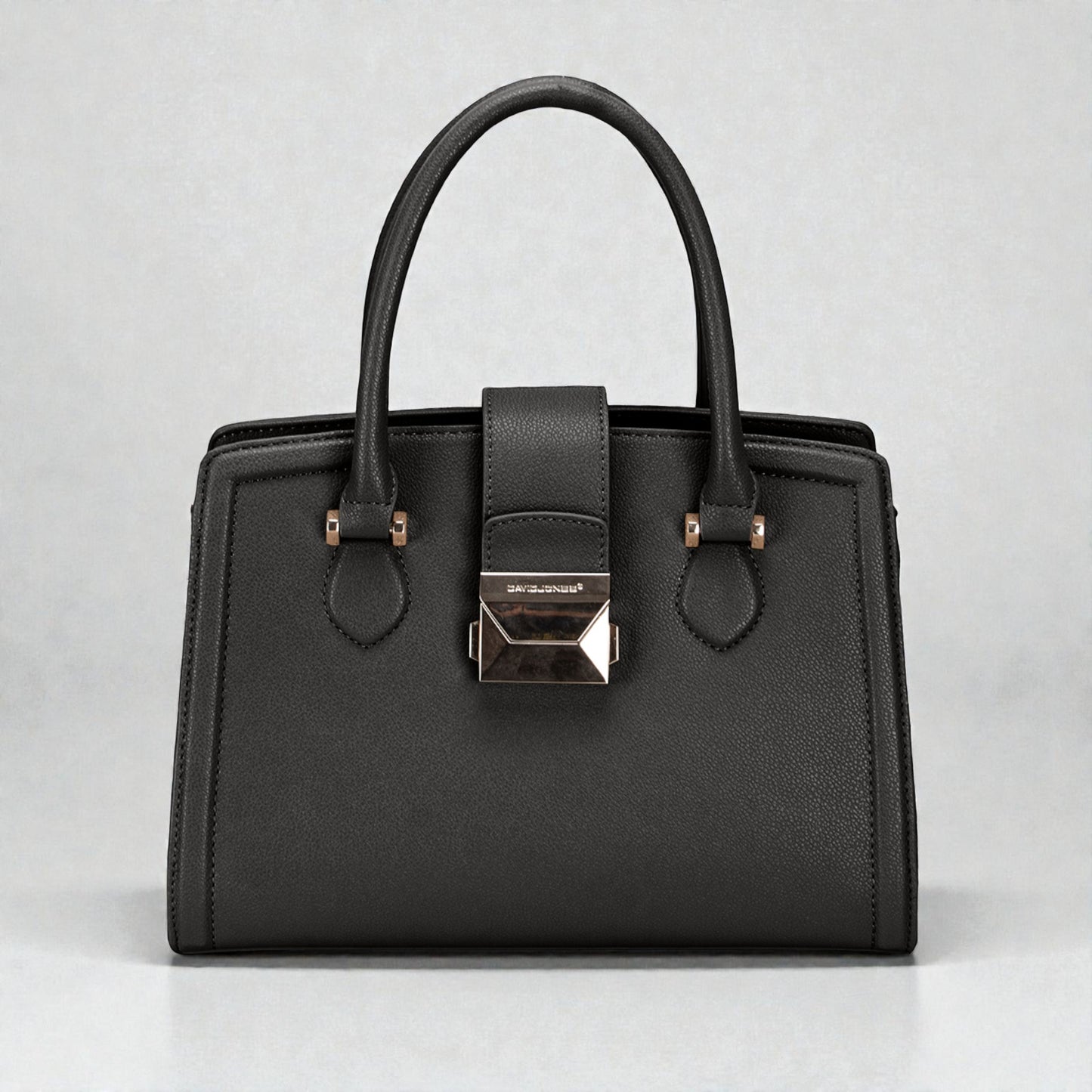 Black handbag with a silver clasp on a light gray background