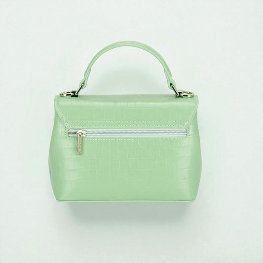Mint green handbag with a silver zipper on a light gray background