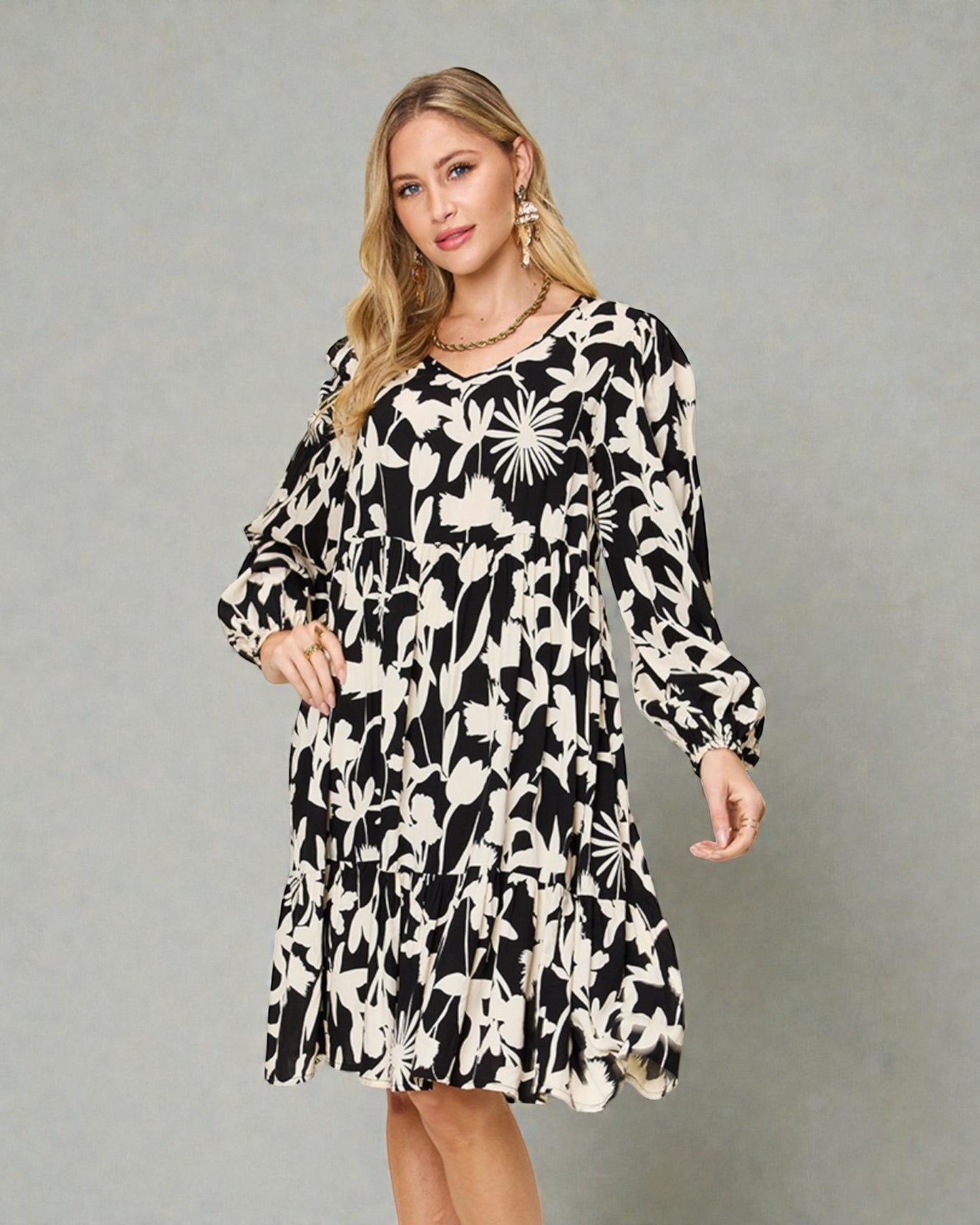 Woman wearing a black and white floral dress against a gray background