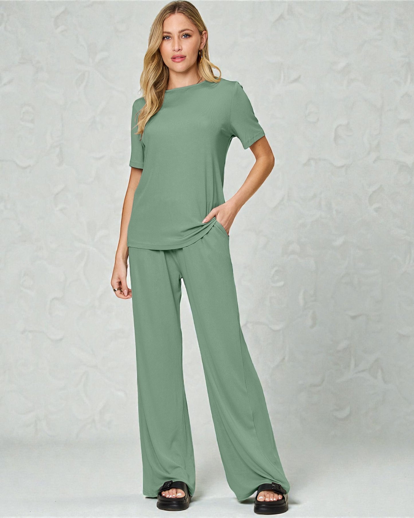 Woman wearing a green outfit against a plain background