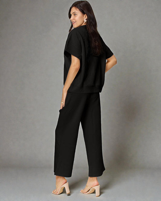 Woman wearing a black outfit against a gray background