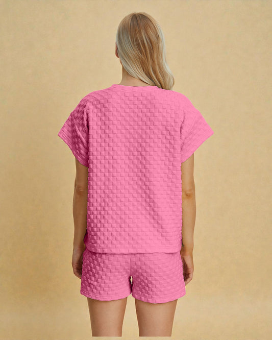 Person wearing a pink textured outfit on a beige background