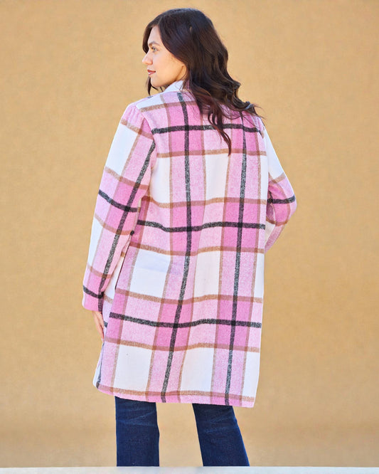 Person wearing a pink and white plaid coat against a beige background