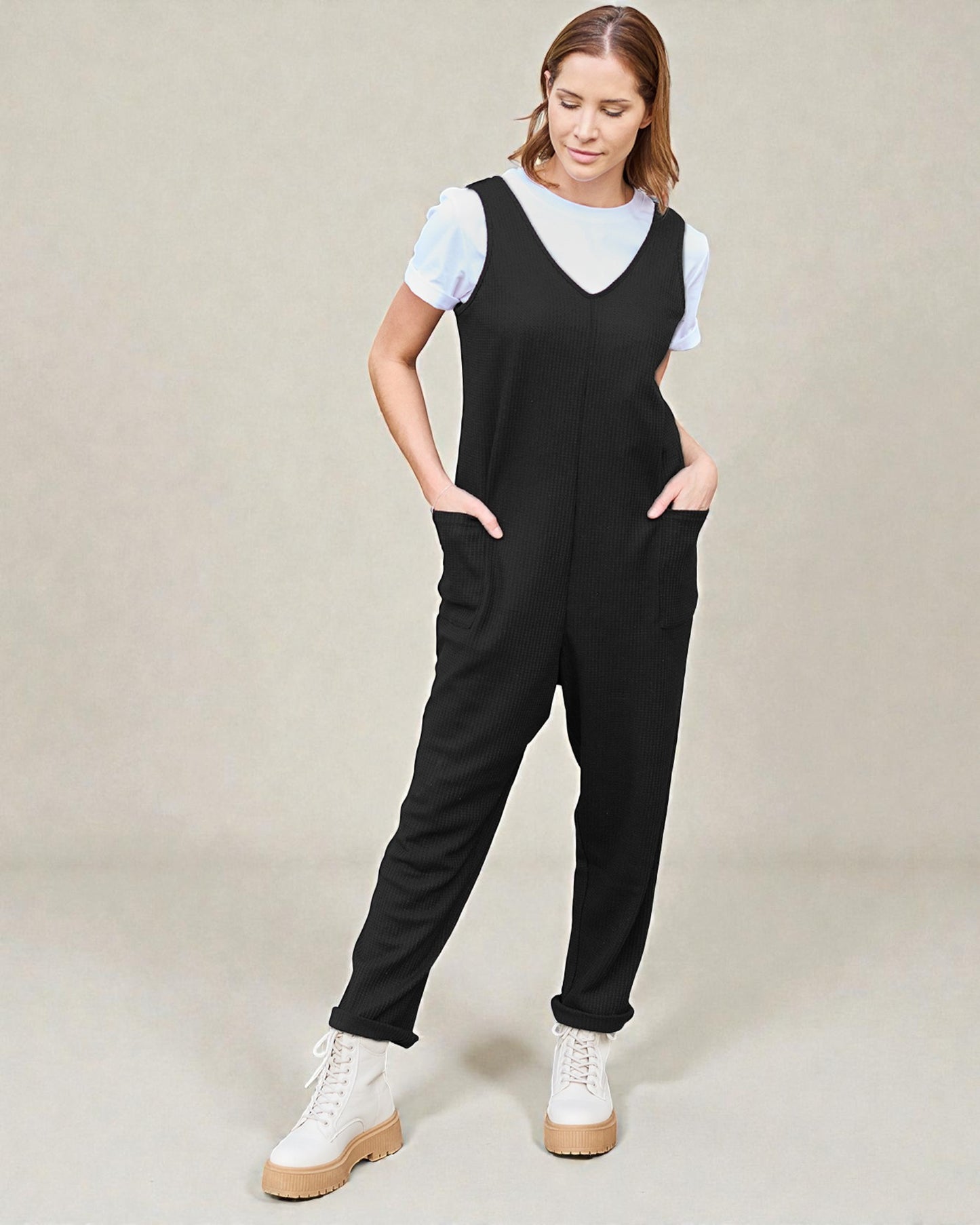 Woman wearing a black jumpsuit with a white background