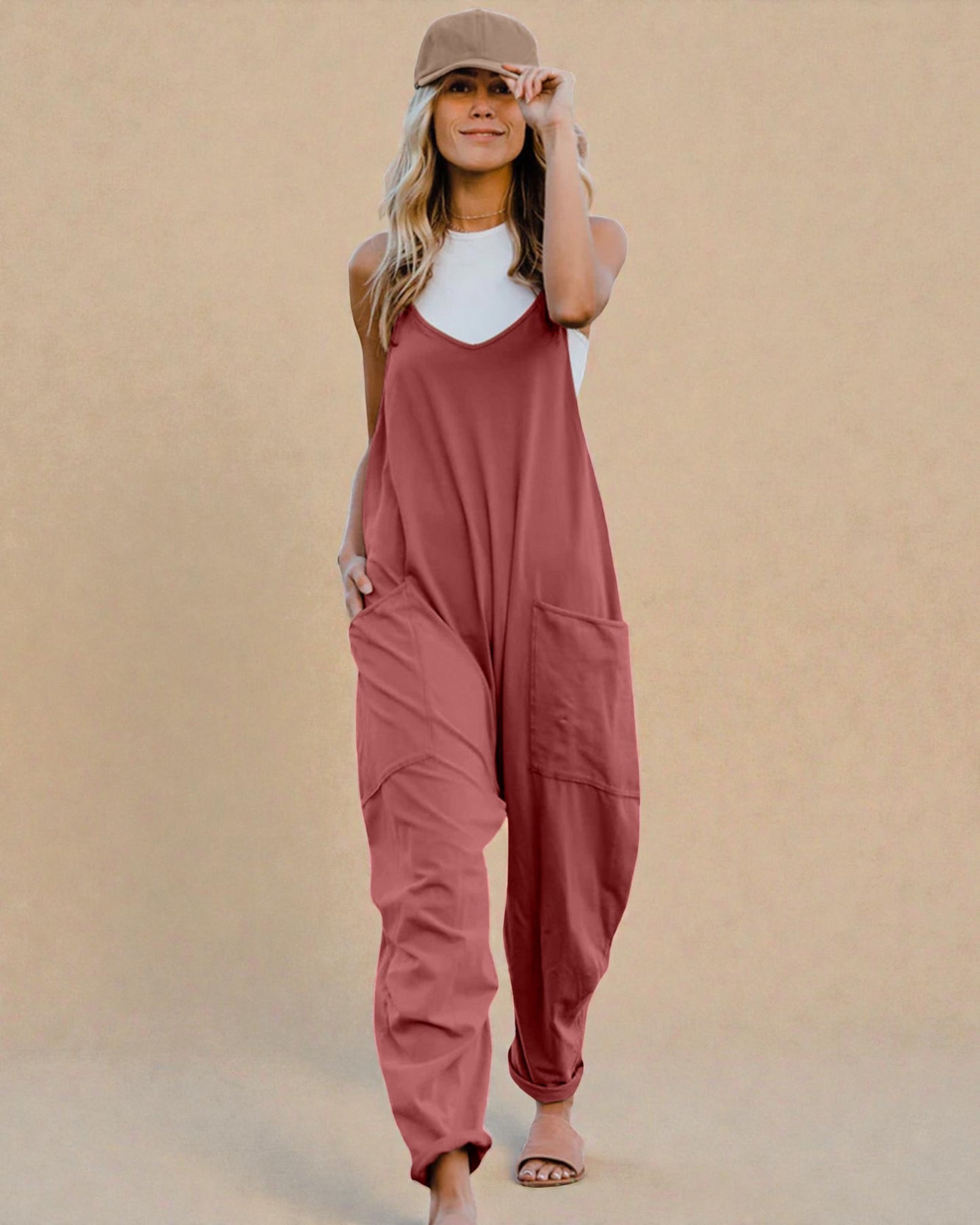 Woman wearing a pink jumpsuit against a beige background