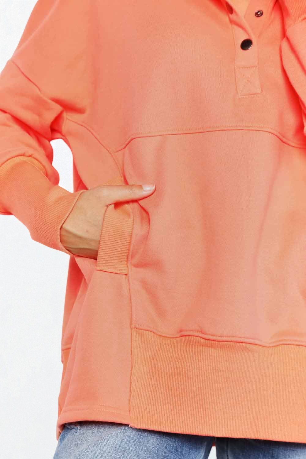 Close-up of an orange hoodie with a white background