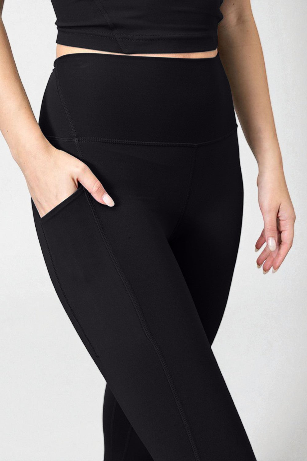 Person wearing black high-waisted pants on a white background