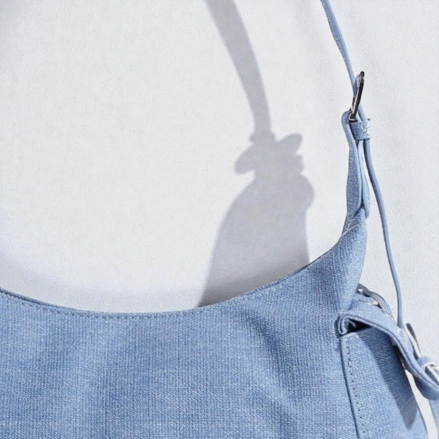 Light blue denim dress with straps on a white background