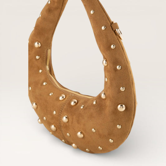 Brown suede handbag with gold studs on a light gray background