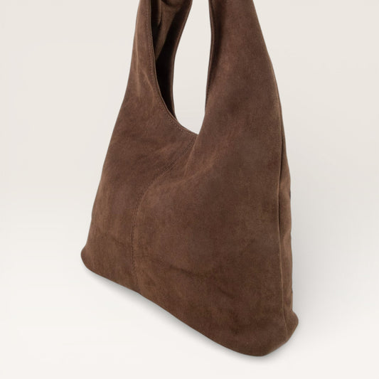 Brown suede handbag on a light gray background