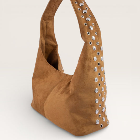 Brown suede handbag with studded details on a light gray background