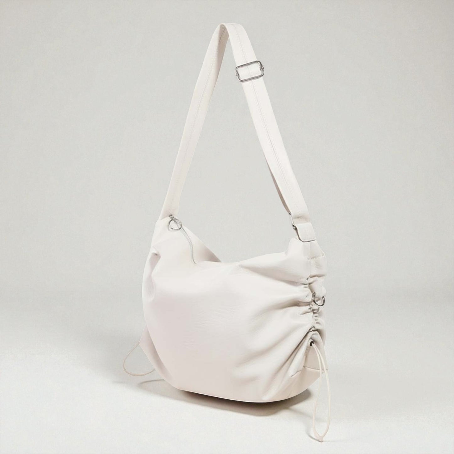 White handbag with a strap on a light gray background