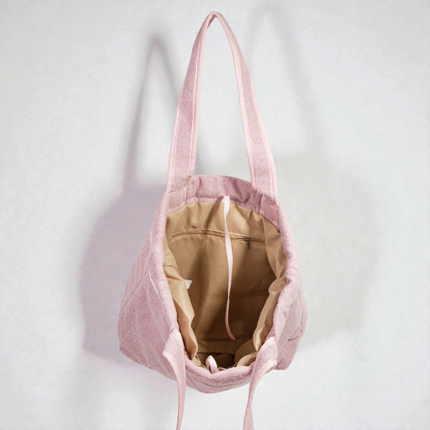 Pink tote bag with a beige interior on a white background