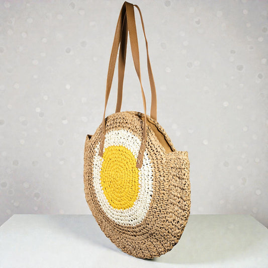 Round woven bag with a yellow and white center on a light gray background
