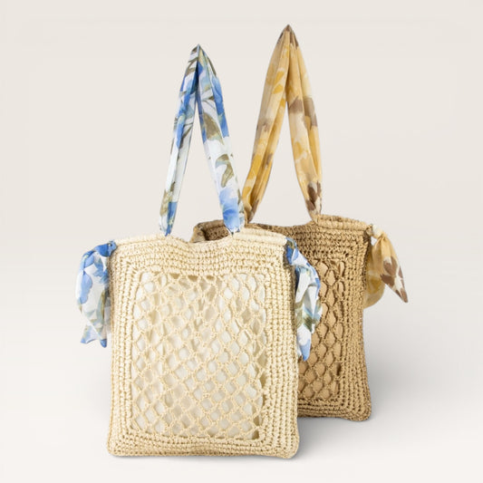 Two woven handbags with floral scarves on a light background