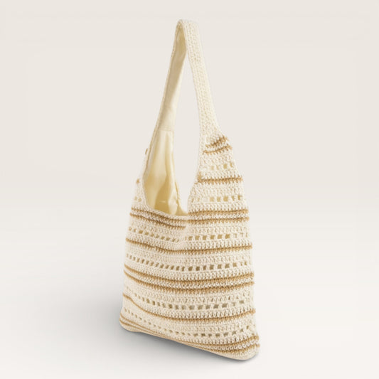 Crocheted bag with a gold handle on a light gray background