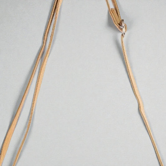 Gold necklace on a light gray background