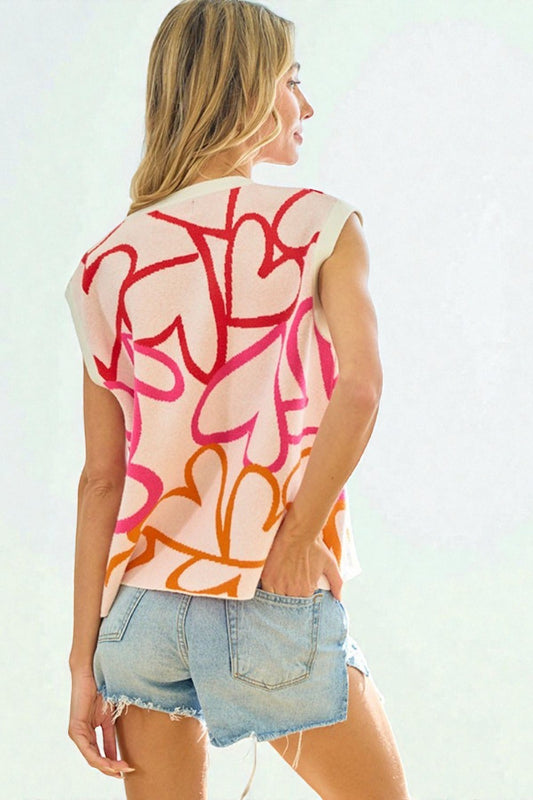 Woman wearing a sleeveless top with colorful abstract design and denim shorts on a white background