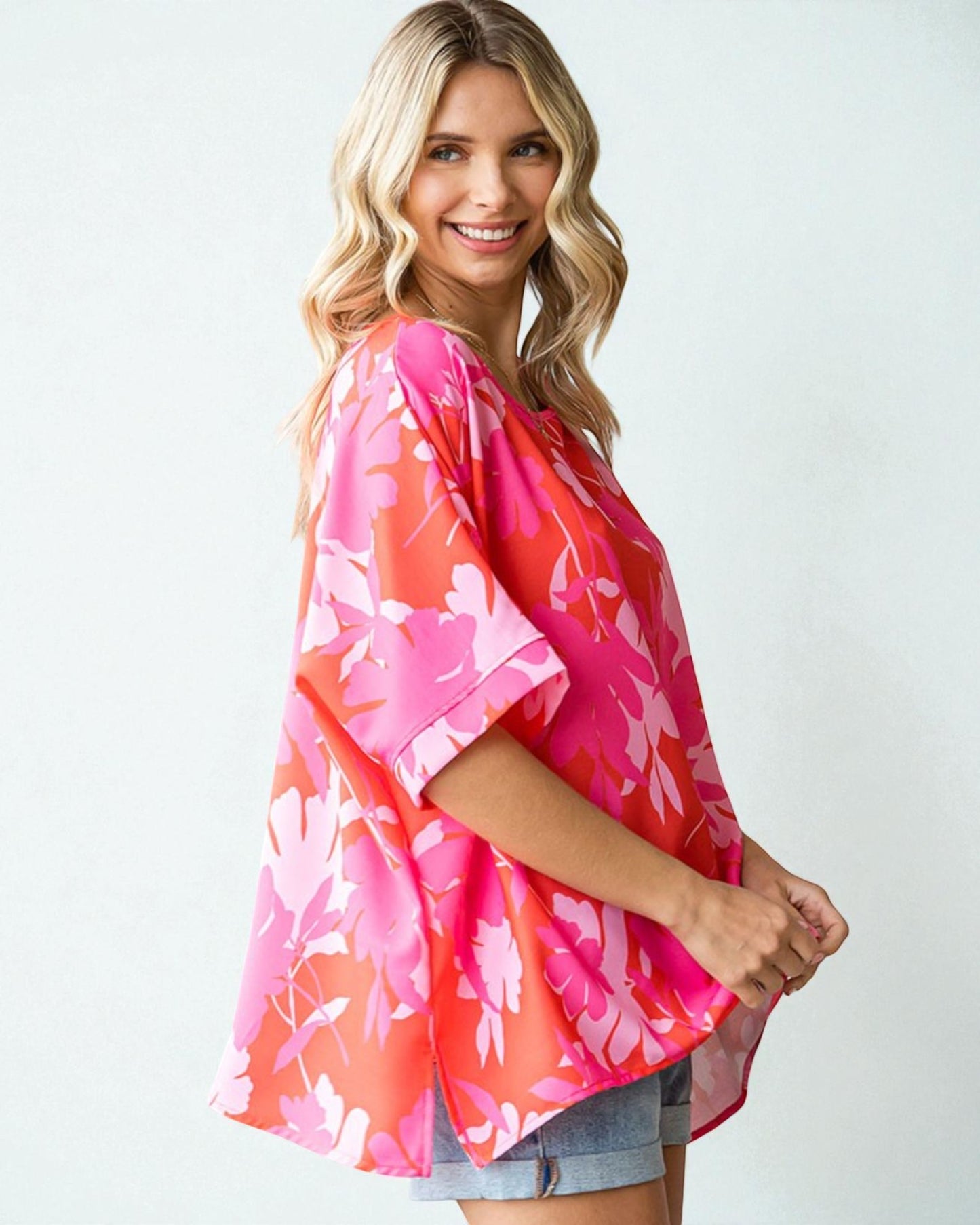 Woman wearing a pink floral kimono against a white background