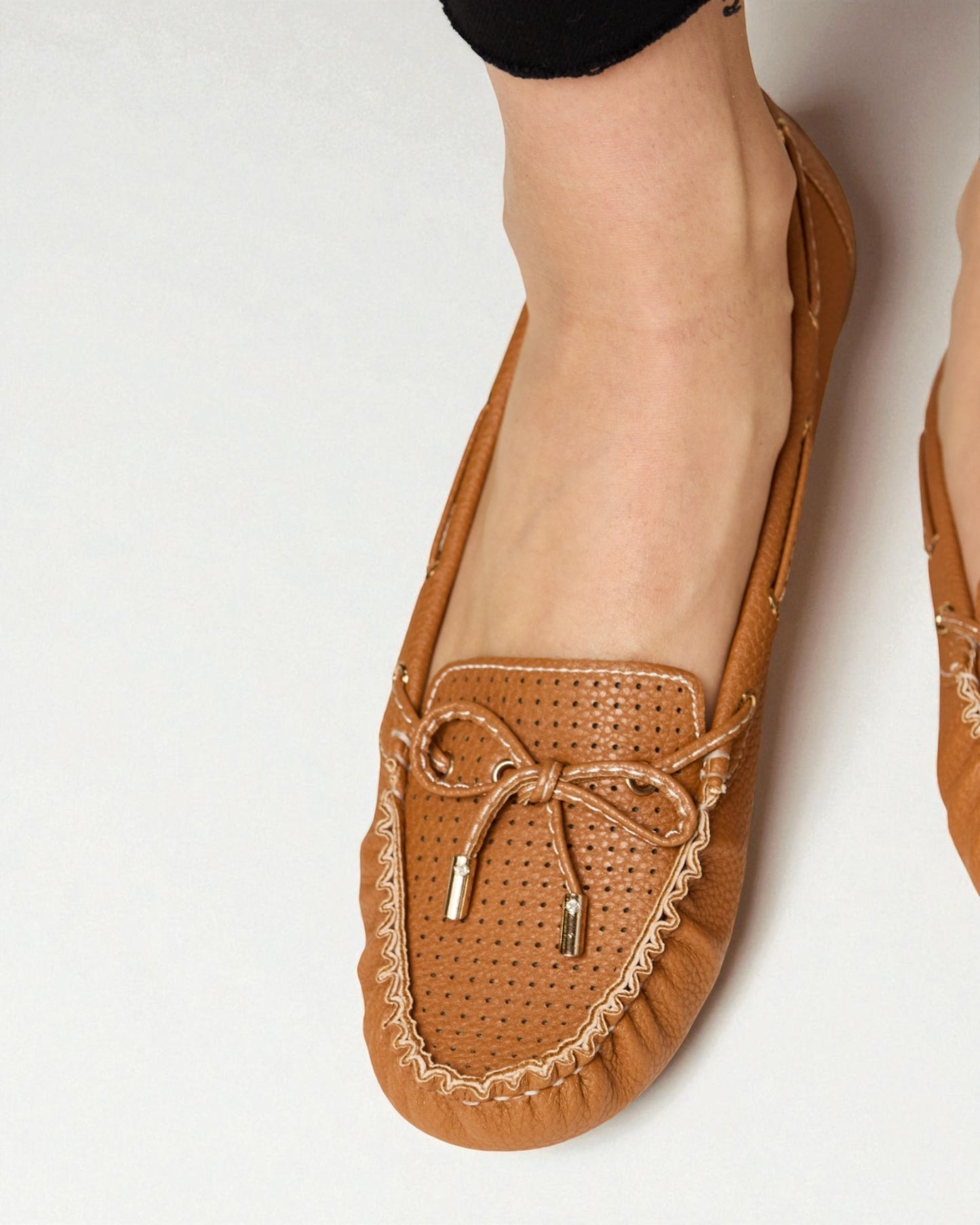 Brown loafers with decorative elements on a white background