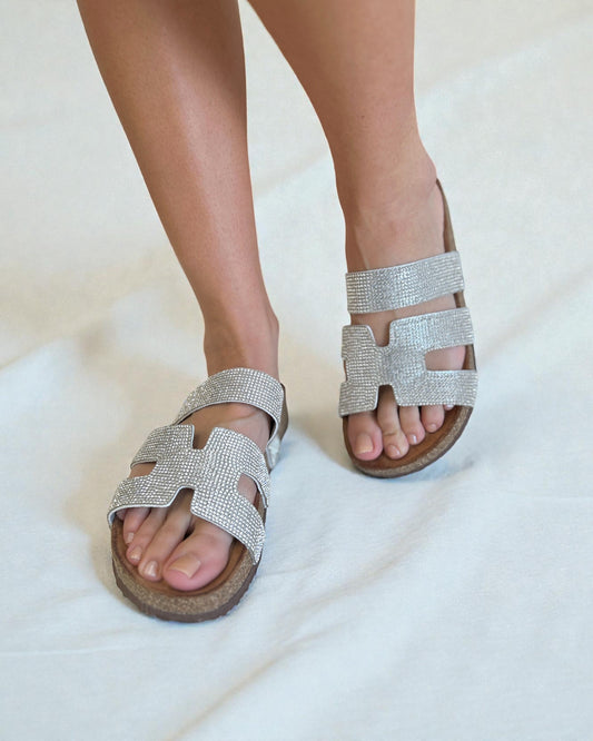 Silver embellished sandals on a white background