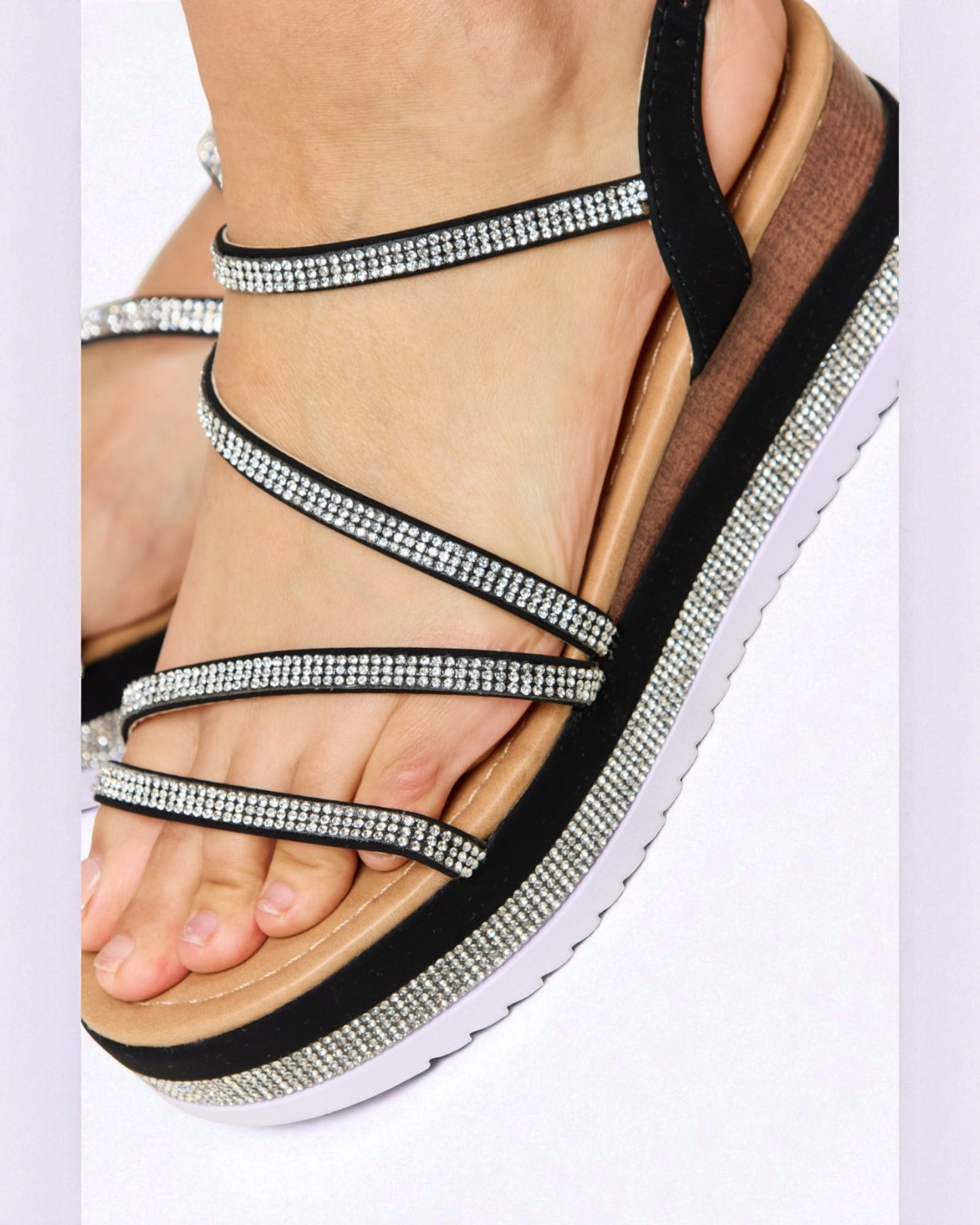 Black sandal with rhinestone straps on a white background
