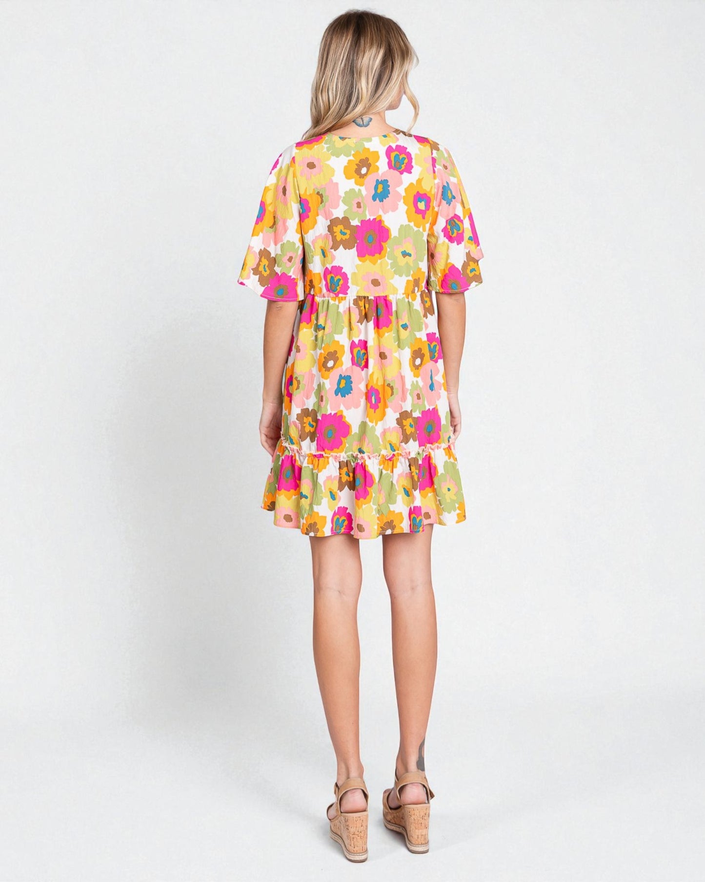 Woman wearing a colorful floral dress on a white background