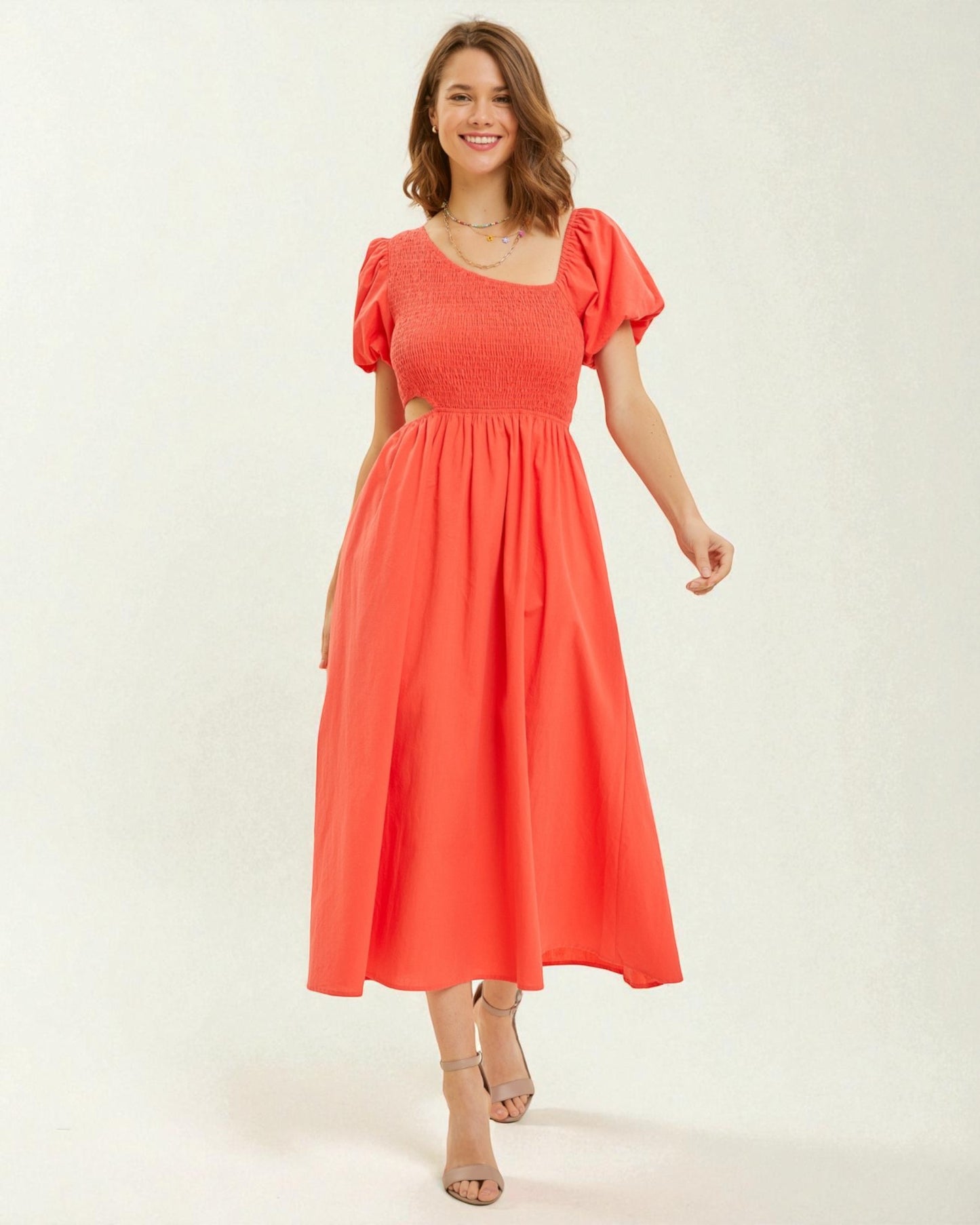 Woman wearing a coral dress on a white background
