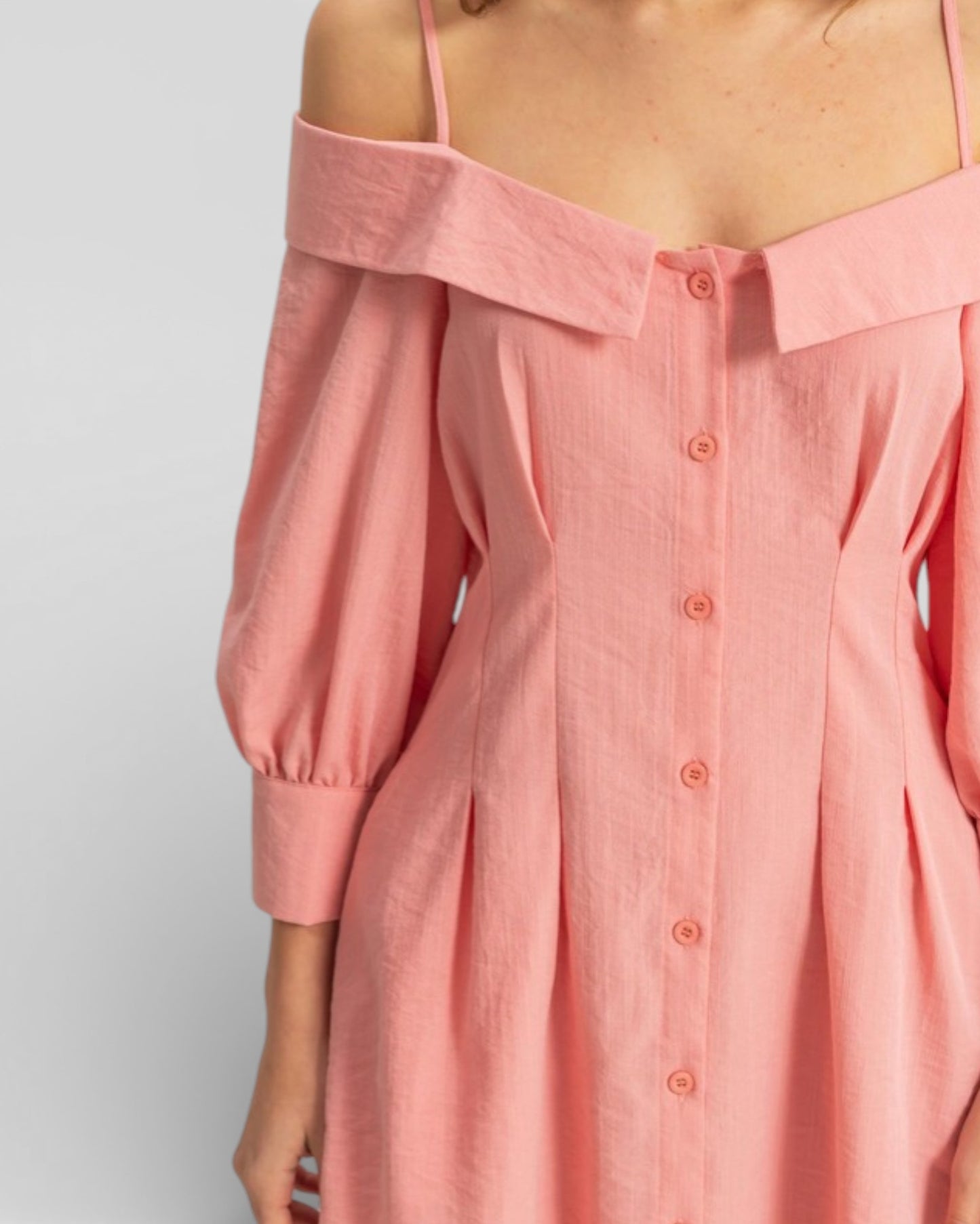 Pink off-shoulder dress on a plain background