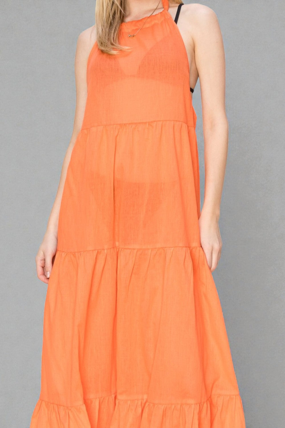 Orange dress worn by a person on a gray background
