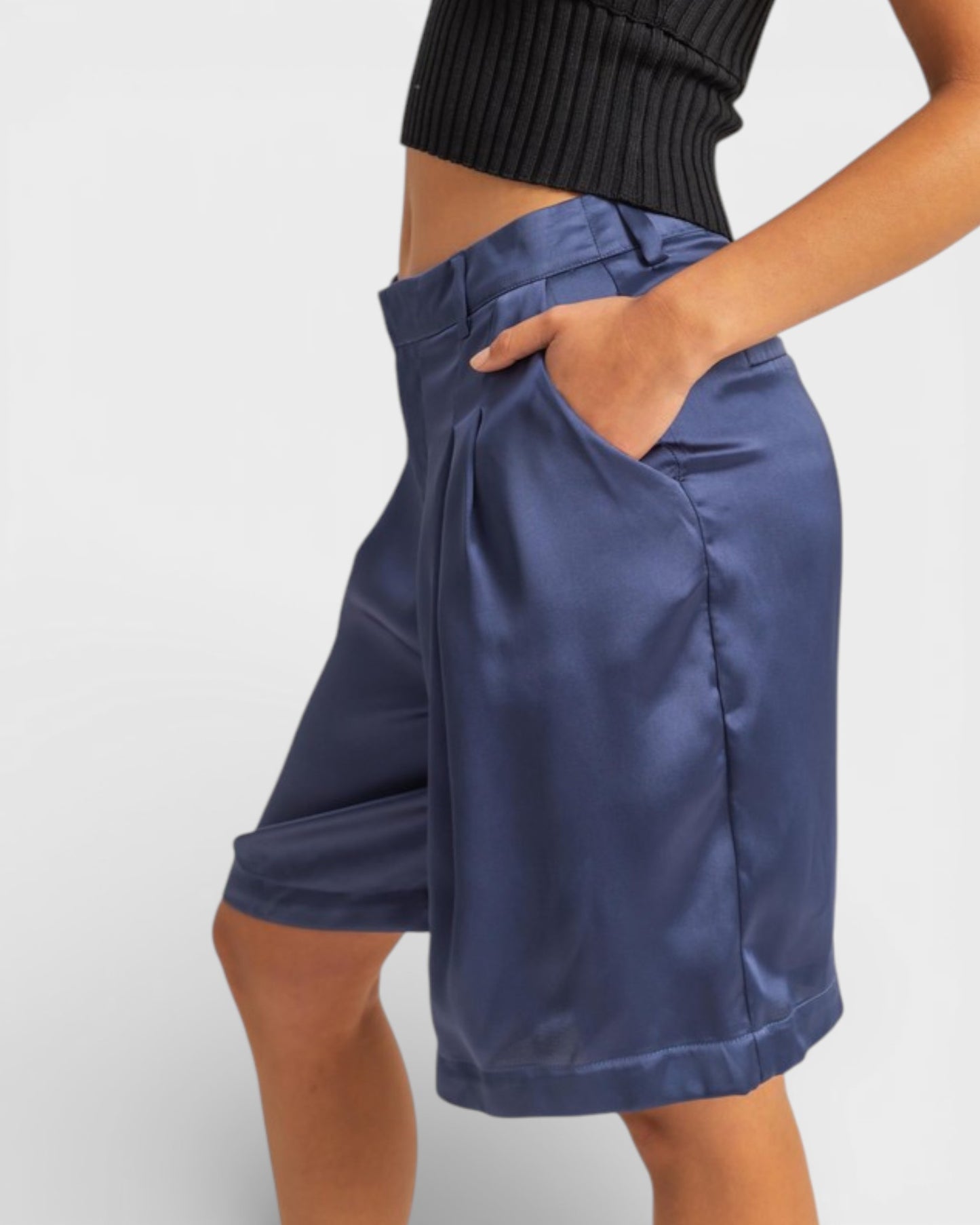 Blue shorts worn by a person on a plain background