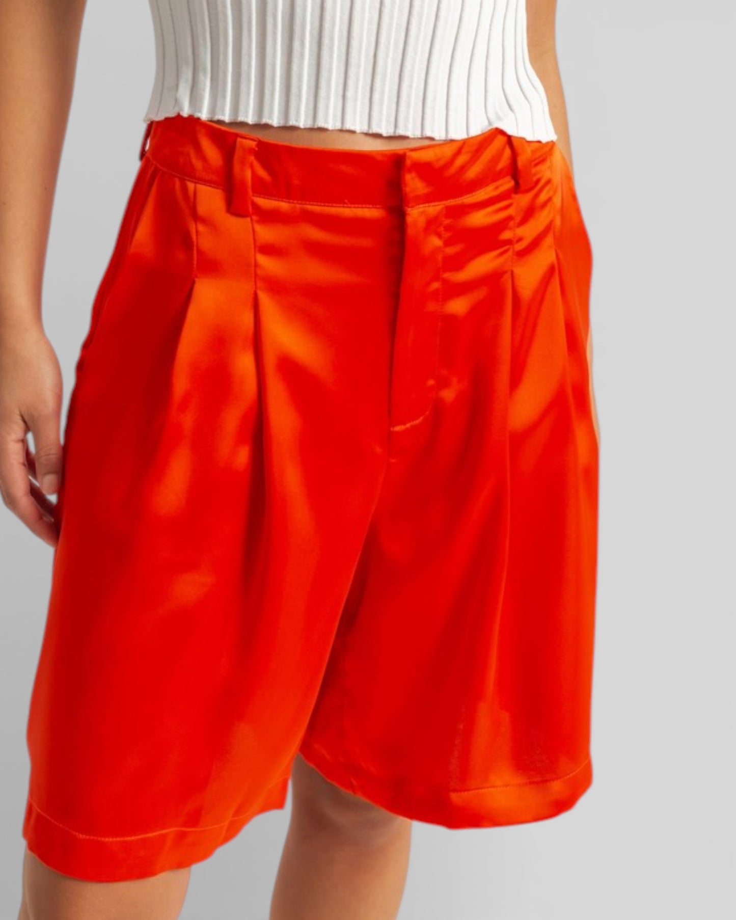 Person wearing bright orange shorts on a plain background
