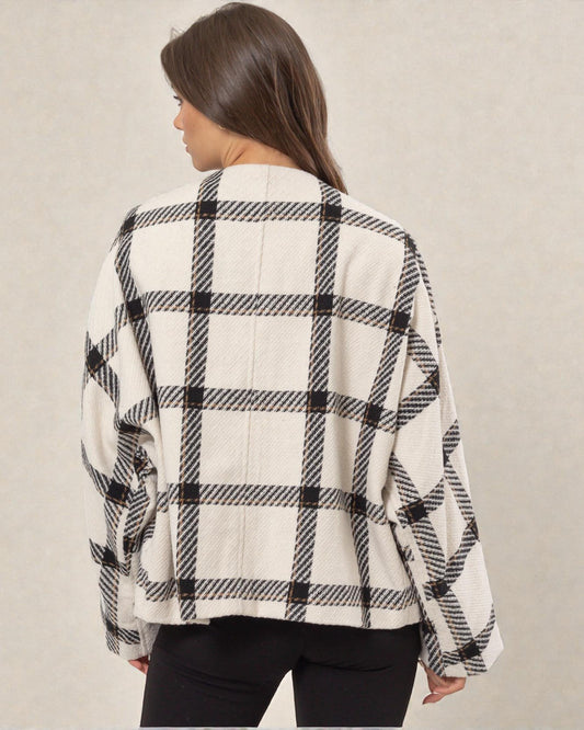 Person wearing a black and white checkered shirt against a plain background