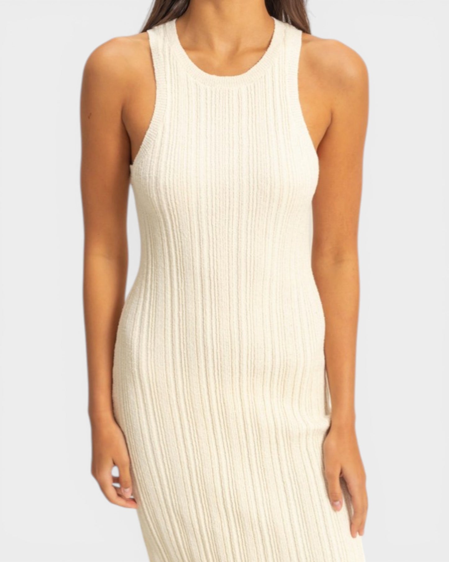 Woman wearing a beige ribbed dress against a white background