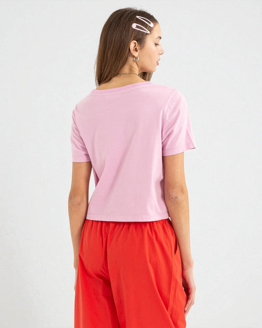 Person wearing a pink top and red pants on a white background
