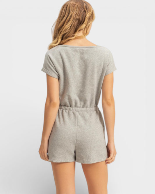 Woman wearing a gray romper on a white background