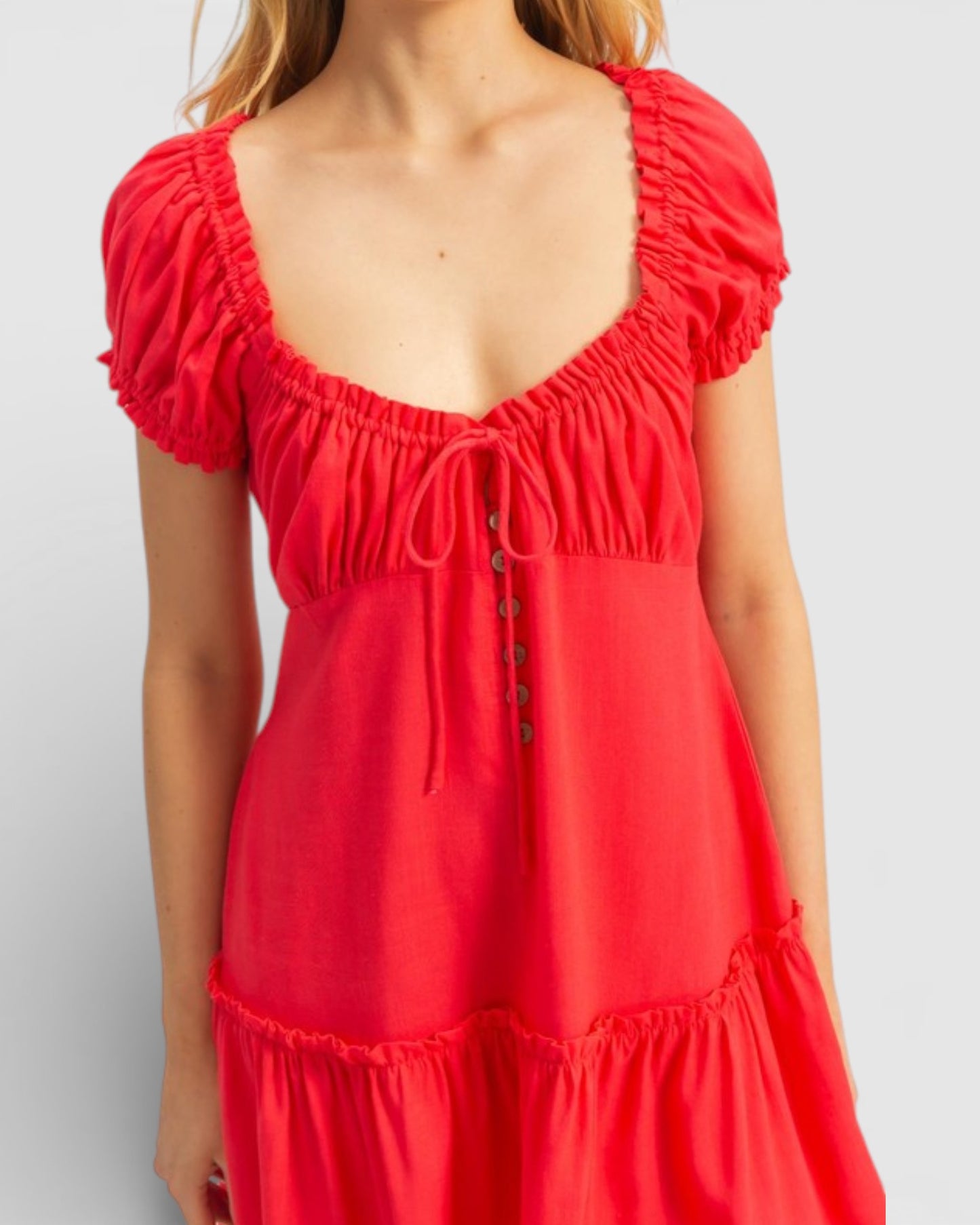 Red dress with ruffled sleeves and neckline on a plain background