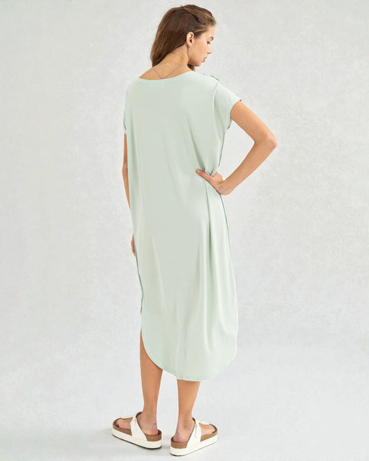 Woman wearing a light green dress on a plain background