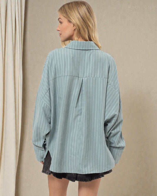 Woman wearing a light blue corduroy shirt against a beige background