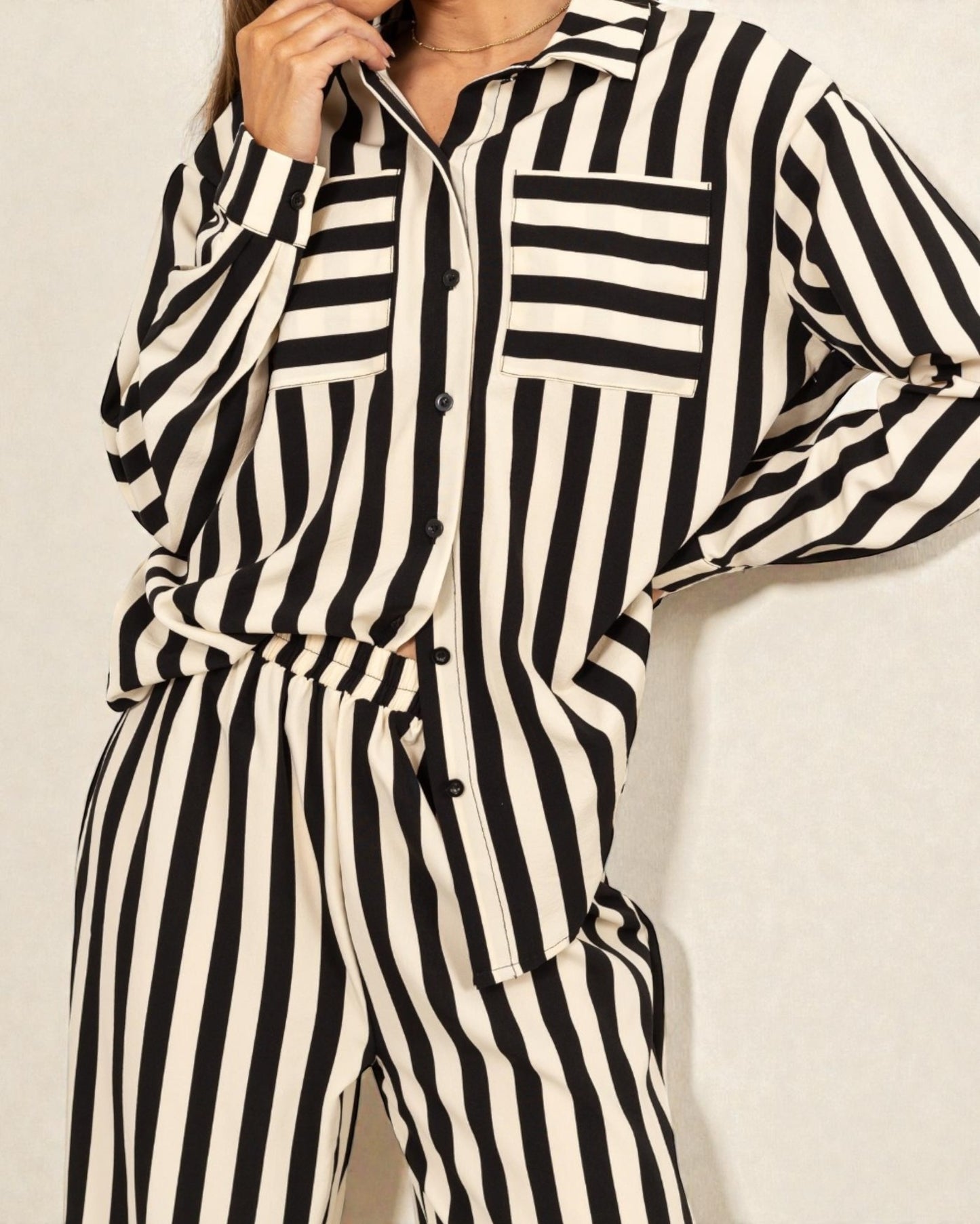 Black and white striped jumpsuit on a plain background
