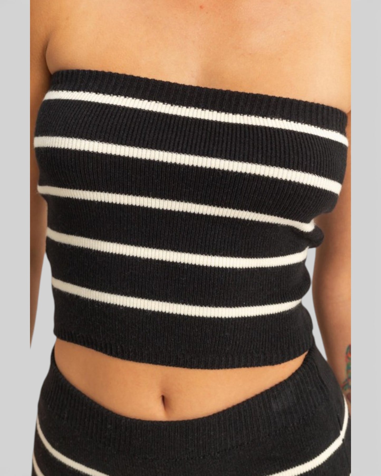 Black and white striped tube top on a plain background
