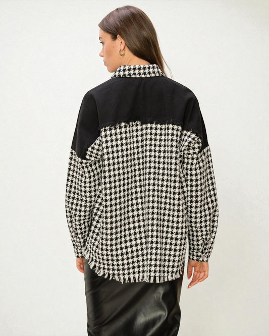 Person wearing a black and white checkered shirt with a plain background