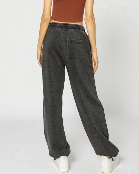 Person wearing dark gray sweatpants on a white background