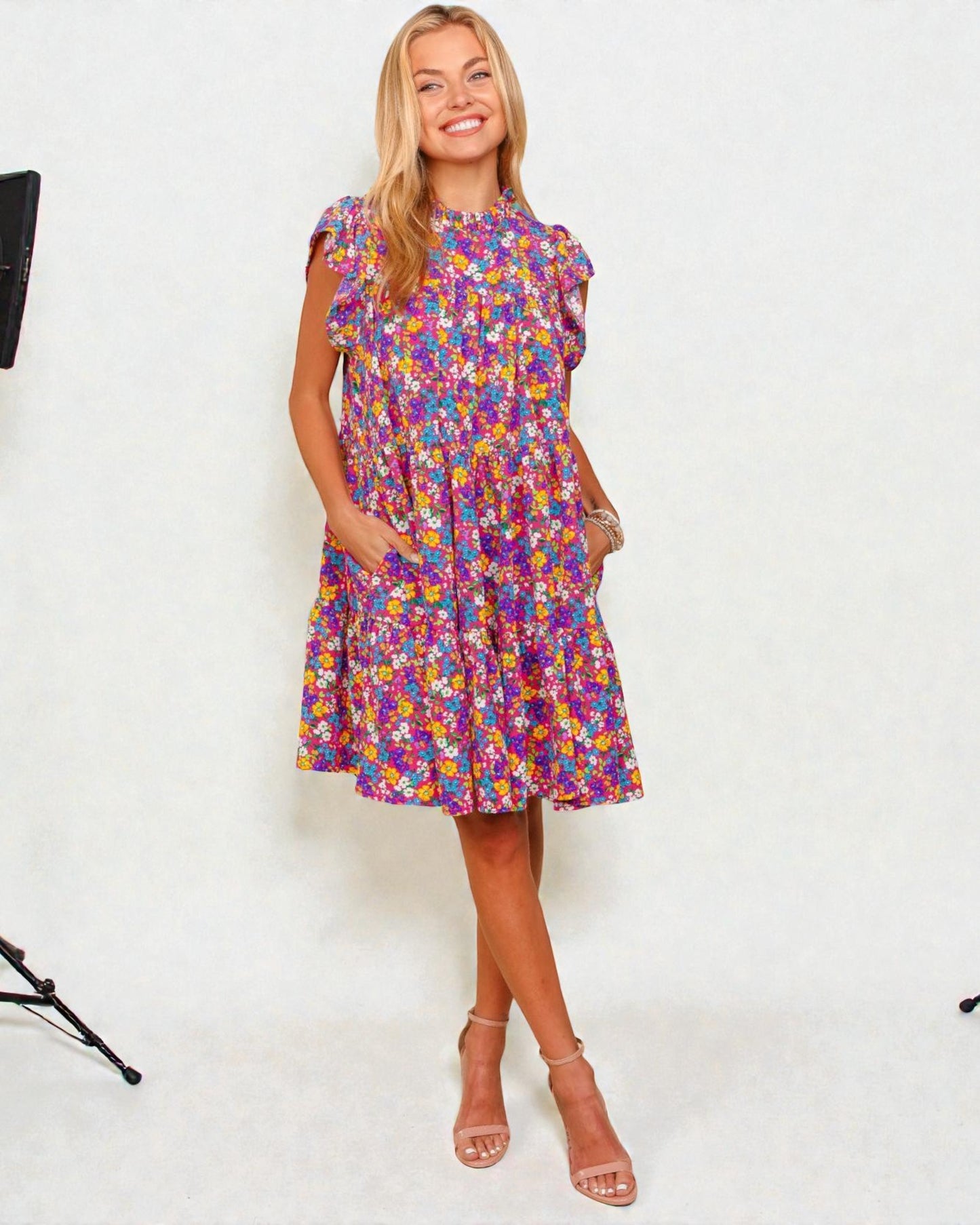 Woman wearing a colorful floral dress against a white background