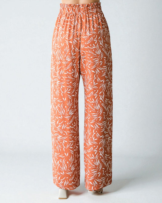 Orange pants with white leaf pattern on a white background