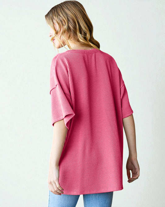 Woman wearing a pink ribbed sweater on a white background