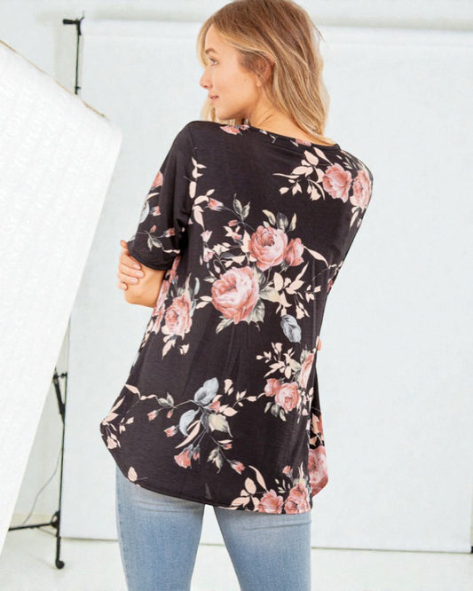 Woman wearing a black floral long-sleeve top against a white background