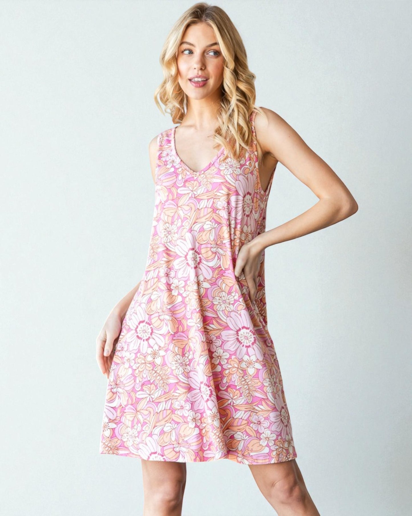 Woman wearing a pink floral dress against a white background