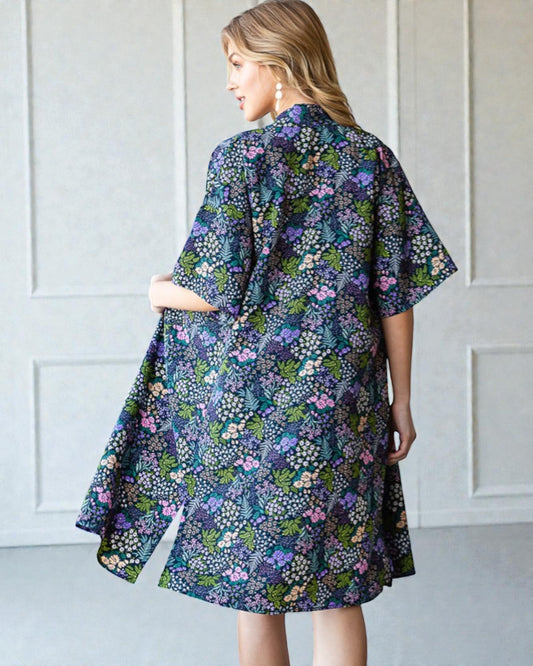 Woman wearing a floral dress against a white paneled wall
