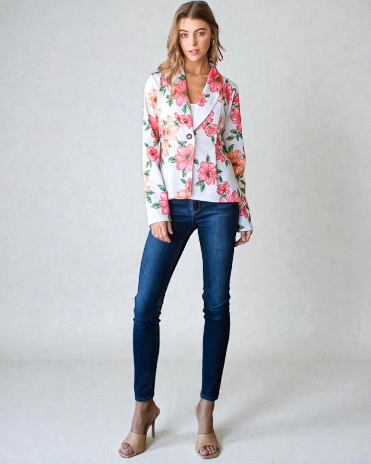 Woman wearing a floral blouse and blue jeans on a plain background